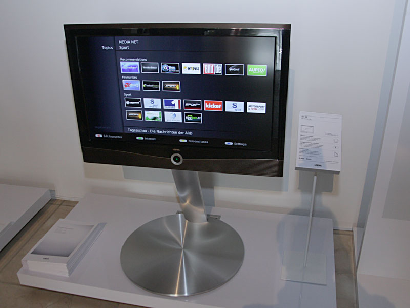 デザイン性の高い家電で知られる独LOEWE(レーベ)は、フレームシーケンシャル方式の3D対応テレビ「Individual 46 Compose 3D」(写真左/5,100ユーロ)を中心に展示。アクティブシャッターの3Dメガネ(750ユーロ)や、ヤマハと共同開発した専用フロントサラウンドスピーカーの「サウンドプロジェクター」(1,600ユーロ)、AVラック、サブウーファ、iPodドック搭載のメディアセンターなどと組み合わせて紹介した。このテレビ「Individual」の内蔵HDDで録画した番組を、LAN経由で32型テレビ「Art 32」(写真右/2,400ユーロ)から視聴できるデモも