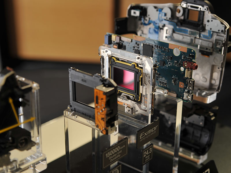 <FONT size=2>α77の分解展示。中央にあるのがミラー部分。透過タイプとなっており、反射した光を上部のAFユニットに送り、透過した光がセンサー(右の写真)に届く</FONT>