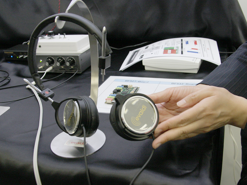 ステレオ再生時に音場が狭くなるのを防ぐNTTエレクトロニクスの技術「HiFiREVERB」を搭載したオーディオボードを提供している日本モレックスは、既存のボードの半分のサイズを実現した最新ボードを開発。遅延時間を従来の17msから10msに短縮したほか、残響帯域も従来の8kHzから12kHzに拡大。小型化したことで、ヘッドフォンなどでの頭内定位改善や、電話会議システムなどへの応用を想定しているという。もともとコネクタメーカーである同社は、ヘッドフォンやスピーカーのユニットも製造。ヘッドフォン試作機(右)も展示していた